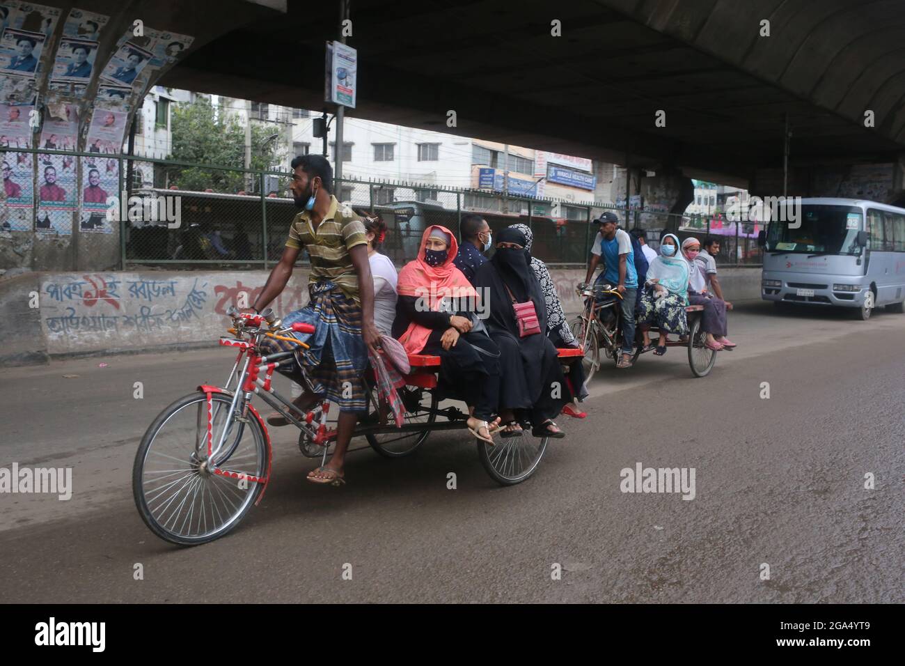 Dhaka, Bangladesh. 29th de julio de 2021. La vida pública en la capital, Dhaka, no se detiene ni siquiera en el severo bloqueo. Aunque todo está cerrado en el encierro, muchas personas están saliendo en caso de emergencia o innecesario. Las máscaras son relativamente usadas, pero la renuencia a mantener la distancia social se ve en casi todo el mundo. Aunque algunas oficinas tienen su propio sistema de transporte, la mayoría de los pasajeros se enfrentan a problemas debido al cierre del transporte público. Van al destino en rickshaw o van o algunos en bicicleta. (Imagen de crédito: © Md. Rakibul Hasan/ZUMA Press Wire) Foto de stock