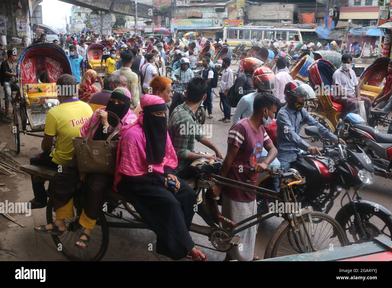 Dhaka, Bangladesh. 29th de julio de 2021. La vida pública en la capital, Dhaka, no se detiene ni siquiera en el severo bloqueo. Aunque todo está cerrado en el encierro, muchas personas están saliendo en caso de emergencia o innecesario. Las máscaras son relativamente usadas, pero la renuencia a mantener la distancia social se ve en casi todo el mundo. Aunque algunas oficinas tienen su propio sistema de transporte, la mayoría de los pasajeros se enfrentan a problemas debido al cierre del transporte público. Van al destino en rickshaw o van o algunos en bicicleta. (Imagen de crédito: © Md. Rakibul Hasan/ZUMA Press Wire) Foto de stock