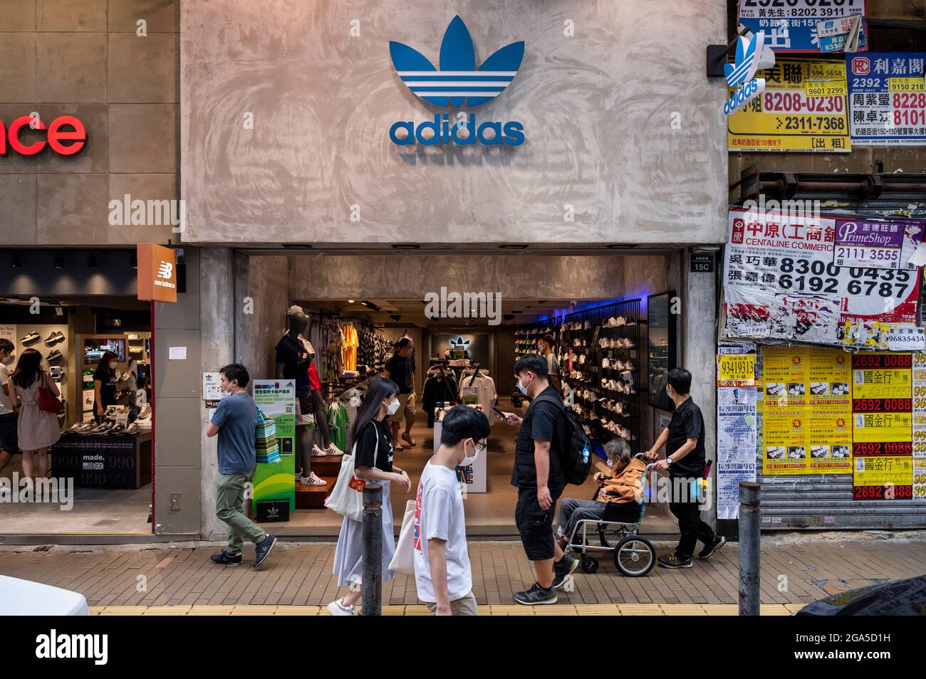 Los peatones pasan por la Marca multinacional alemana de ropa deportiva  Adidas y el logotipo en Hong Kong. (Foto de Budrul Chukrut / SOPA  Images/Sipa USA Fotografía de stock - Alamy