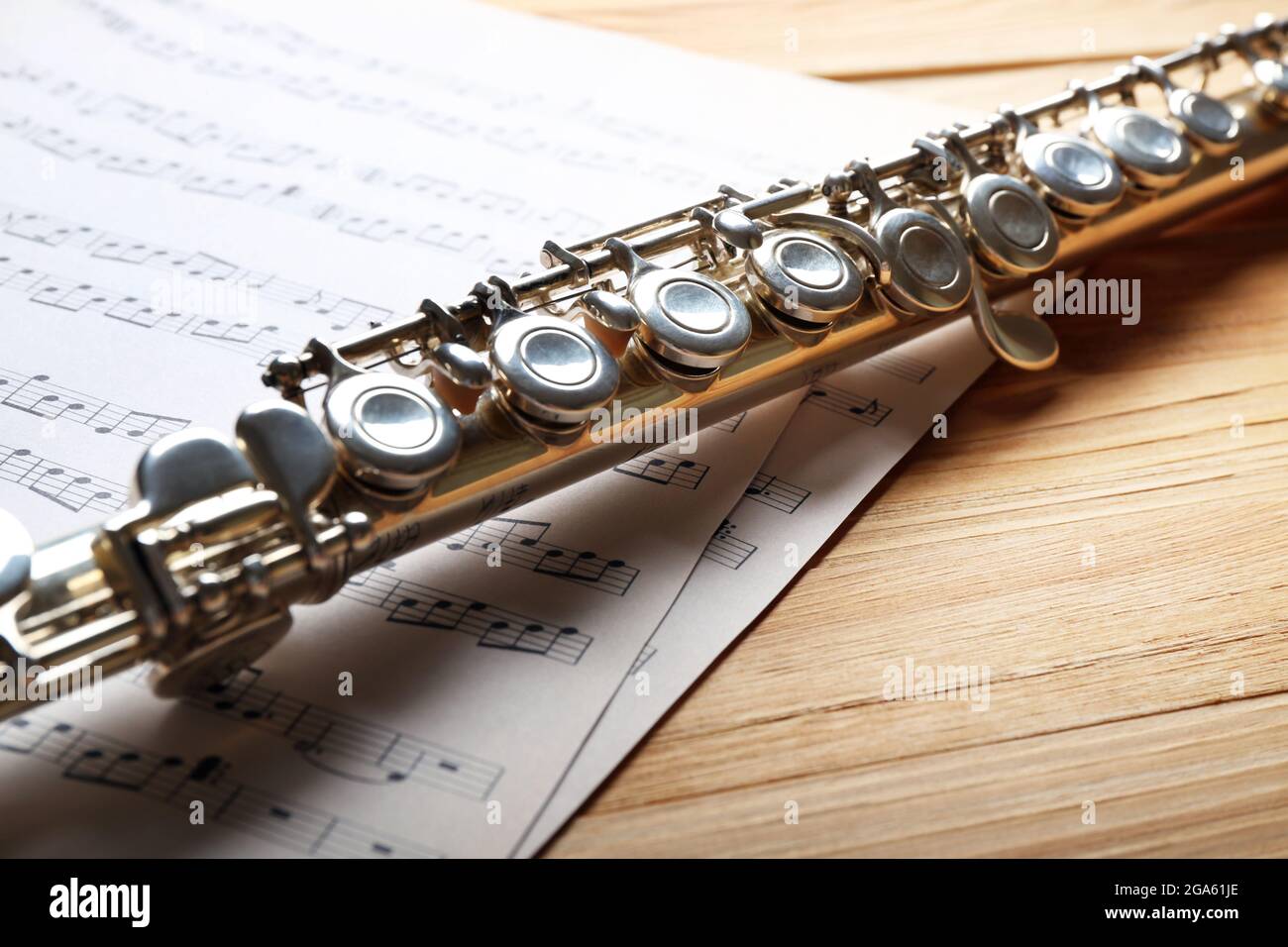 Flauta de plata con notas musicales sobre la mesa de madera cerrar  Fotografía de stock - Alamy