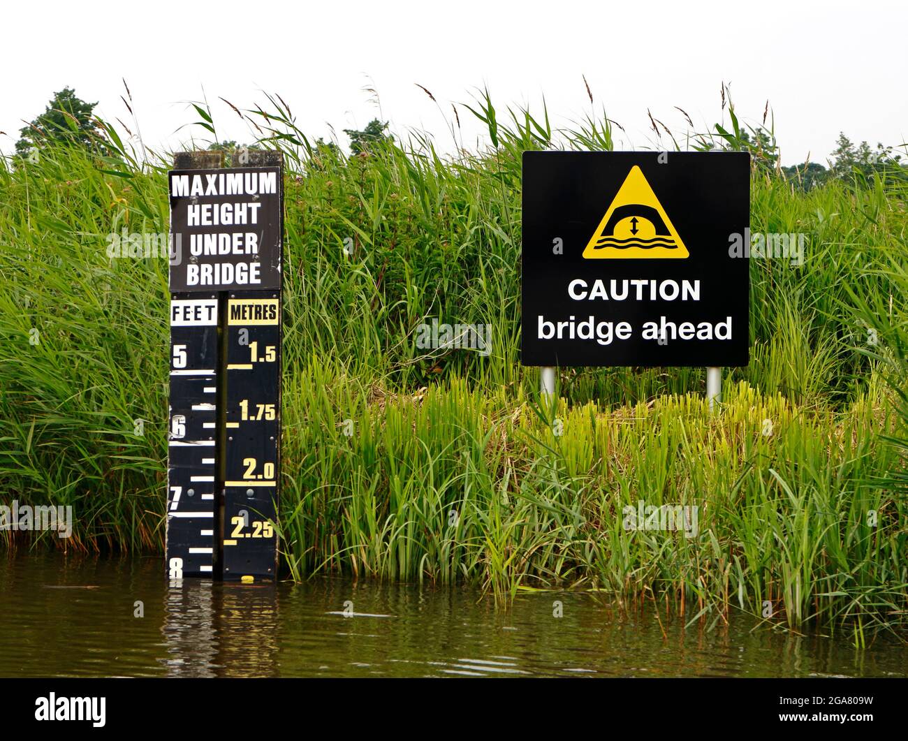 Señales que indican la altura disponible bajo el puente bajo del río Ant en los Norfolk Broads en Ludham Bridge, Norfolk, Inglaterra, Reino Unido. Foto de stock
