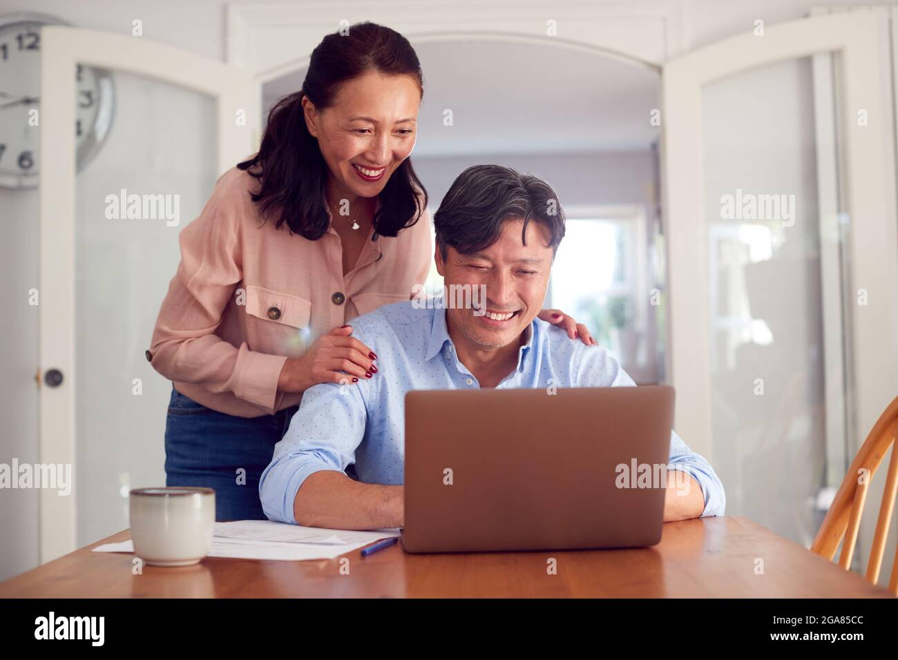 Pareja asiática madura en el hogar usando el ordenador portátil para organizar facturas y finanzas del hogar Foto de stock