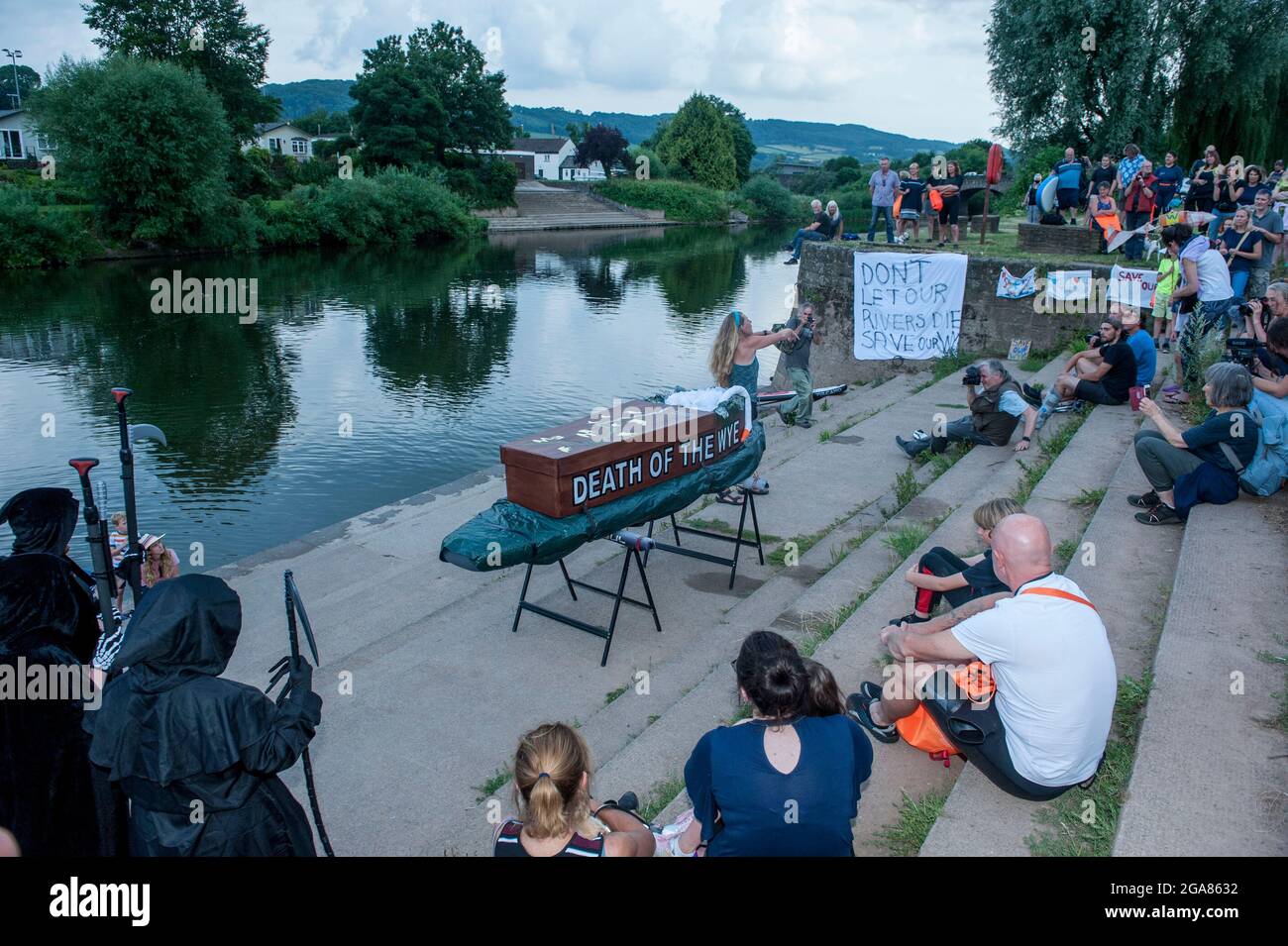 La especialista en natación salvaje y autora Angela Jones aka 'La Mujer Salvaje de la Wye' lleva un baño de 1km en la sección de Monmouth del río Wye para aumentar la conciencia sobre la condición ecológica terrible del río Wye y su continuo deterioro. Una réplica de ataúd en una tabla de paletas fue bajada al río y remolcada por Angela para representar la Muerte de la Wye. Su natación es parte de #SaveTheWye una campaña paraguas para apoyar y construir la red de organizaciones e individuos que trabajan para proteger y restaurar la salud del río Wye y sus afluentes, para beneficio tanto de la vida silvestre como de la gente Foto de stock