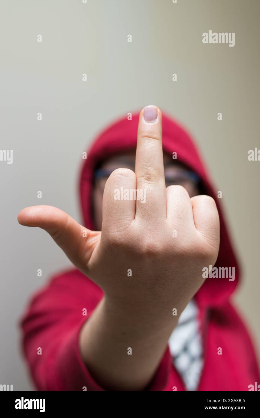 Mujer con chaqueta roja levantando el dedo medio haciendo un símbolo  grosero Fotografía de stock - Alamy