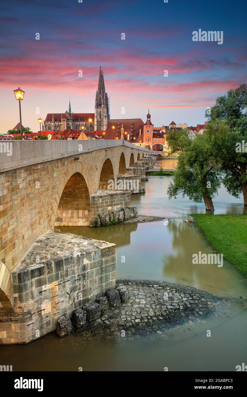 Regensburg, Alemania. Imagen del paisaje urbano de Ratisbona, Alemania, con el puente de piedra antiguo sobre el río Danubio y la catedral de San Pedro al amanecer en verano. Foto de stock