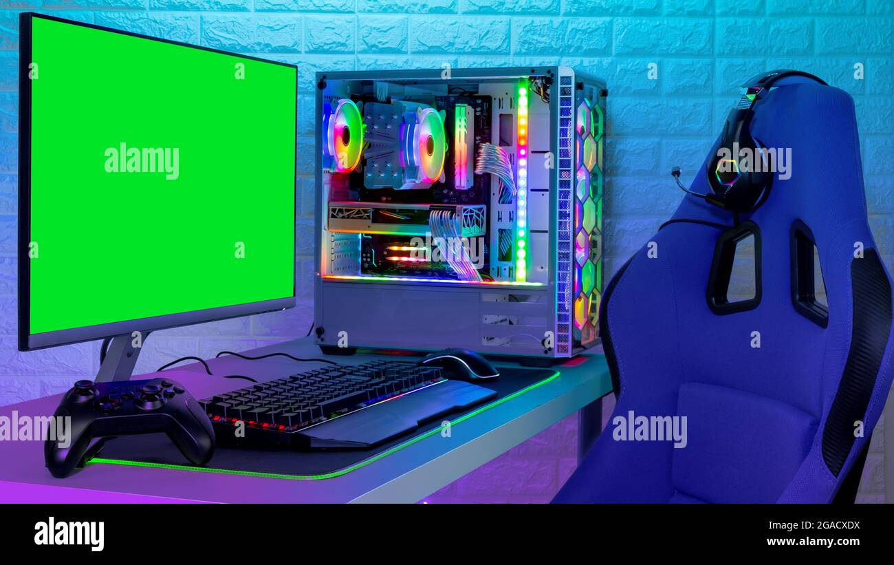 pc de juegos rgb iluminado y colorido con monitor de ratón y teclado con silla y carreras en pantalla frente a la pared de piedra de ladrillo claro LED. Ordenador Foto de stock