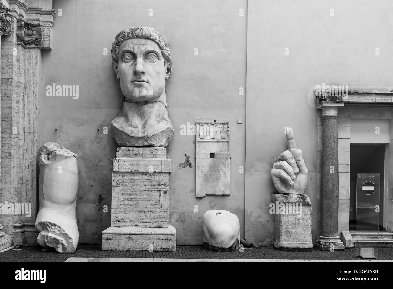 Foto en blanco y negro de piezas de estatuas romanas antiguas en exposición dentro de un museo en Italia Foto de stock