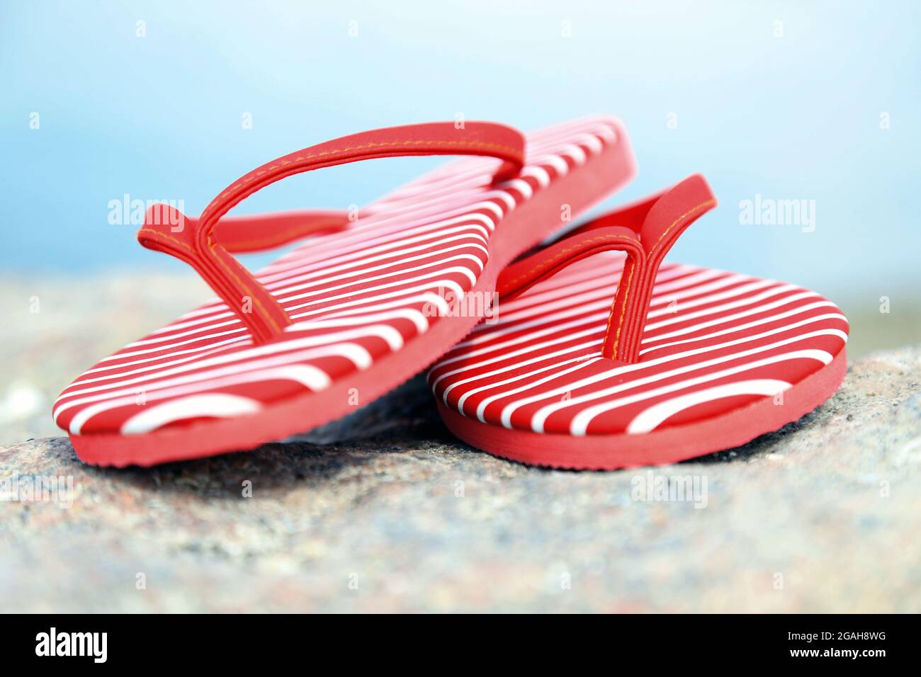 Chanclas brillantes sobre piedra, fondo natural Fotografía de stock - Alamy