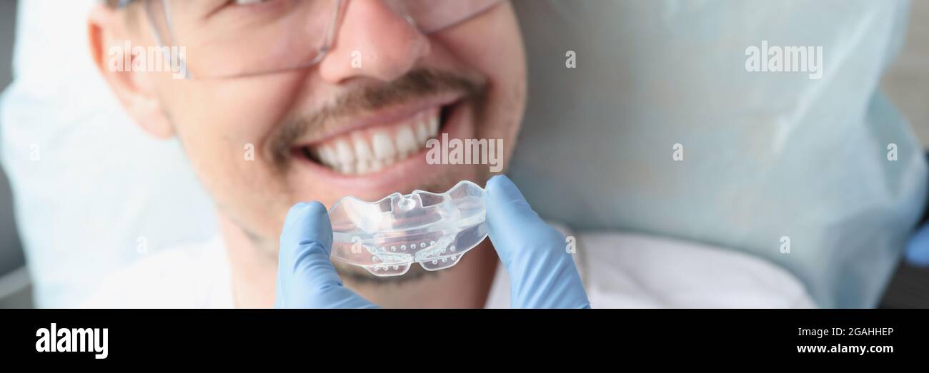 El dentista intenta usar un protector bucal transparente para corregir la  mordida y el bruxismo problemas Fotografía de stock - Alamy