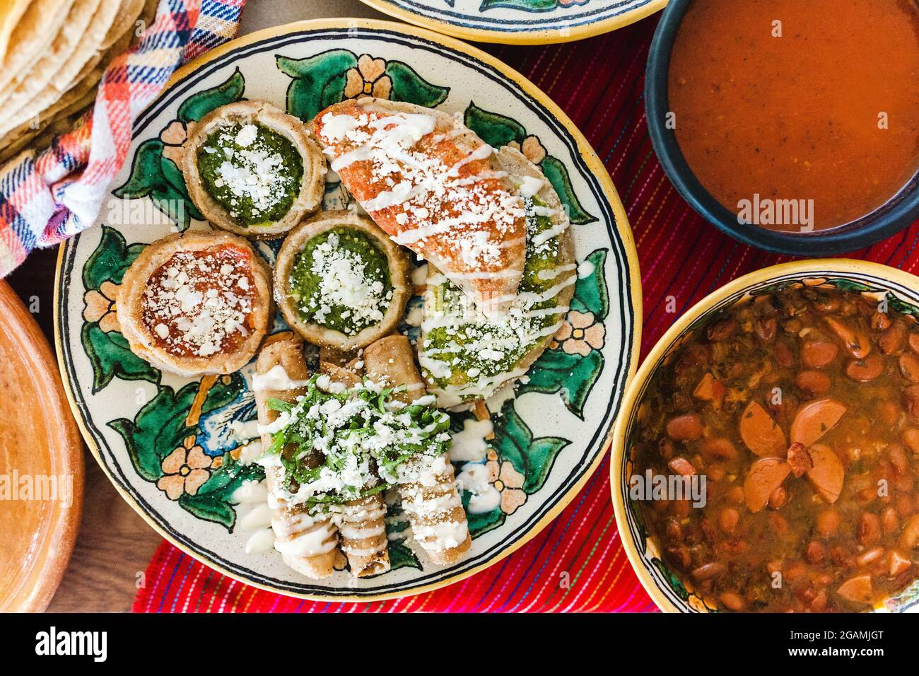 Tacos dorados con pollo y sopes con salsa roja y verde, frijoles