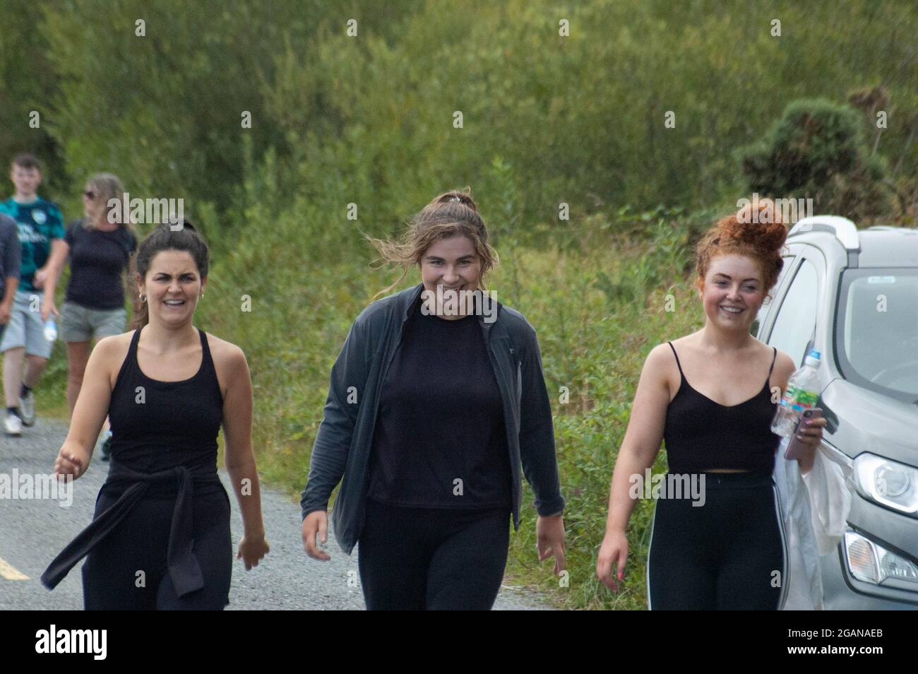 SAT 31 Jul 2021 Adrigole, West Cork Irlanda. Familia y Amigos de la víctima de un accidente trágico Tadgh Murphy realizó una caminata conmemorativa en ayuda de la ambulancia aérea de respuesta rápida de la comunidad irlandesa. Tagdh, de 19 años, murió después de que el coche en el que conducía entrara en el río en la carretera Glengarriff-Kenmare junto con otro hombre, Michael Bowen (40) en las primeras horas del lunes 2 Otros hombres sobrevivieron al accidente. Alex Harrington y Rachel Lyne, Gengarriff junto con Beth Cronin, Bantry, disfrutando de la caminata Crédito ED/Alamy Live News Foto de stock