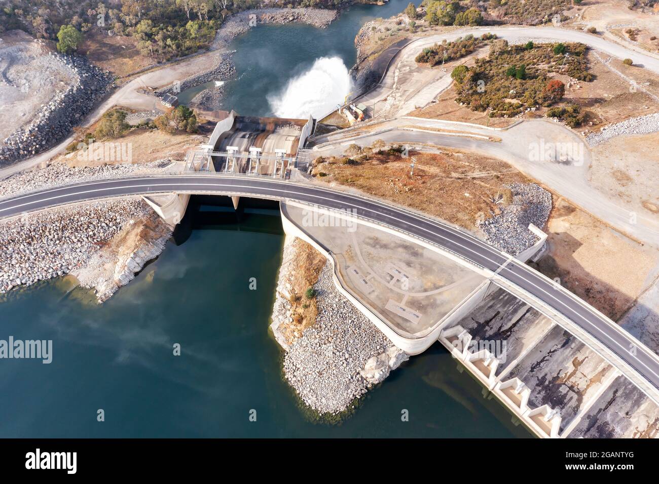 Agua corriente y vertedero de la presa del lago Jindabyne en el río Snowy en las montañas Snowy de Australia - vista aérea de arriba abajo. Foto de stock