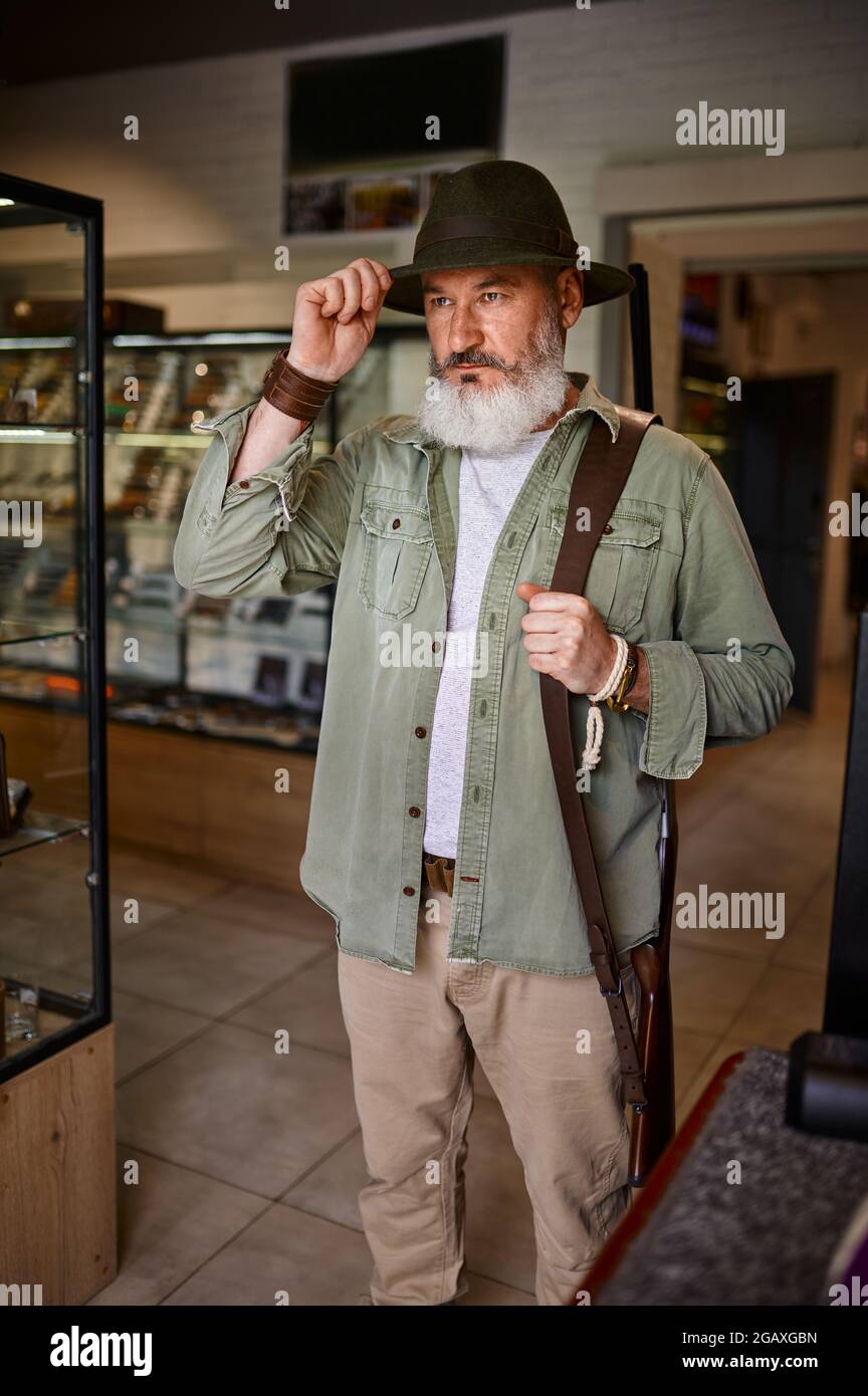 Cazador de hombres barbudos intenta en el sombrero en una tienda de armas  Fotografía de stock - Alamy