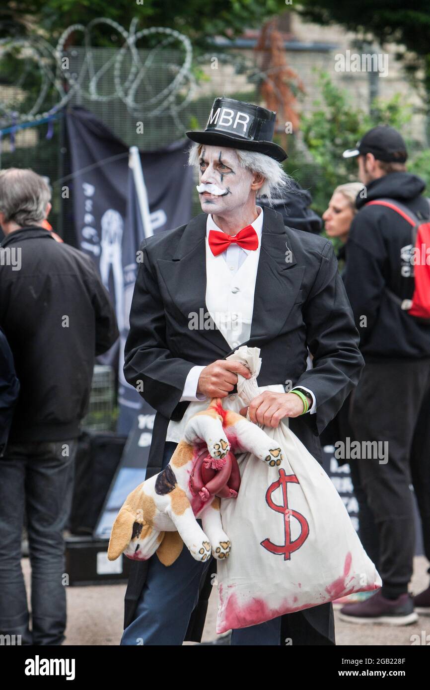 Un manifestante que lleva un traje tiene un juguete mutilado para perros de felpa y una de 'dinero de sangre' durante la manifestación. Manifestantes de todo el país se unieron a