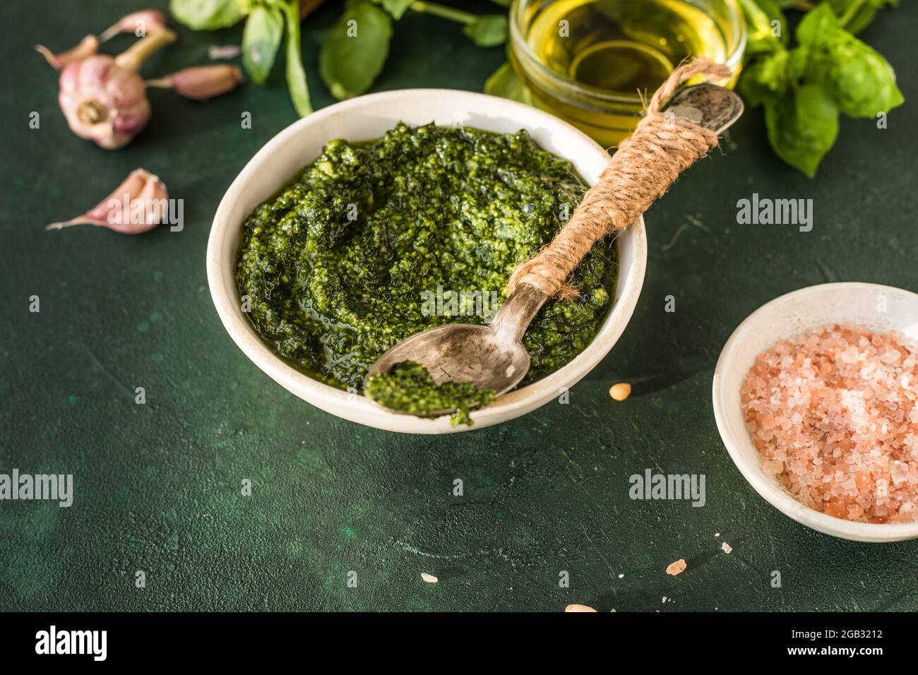 Salsa de pesto en un recipiente con ingredientes sobre una mesa verde  rústica. Receta tradicional italiana de pesto para hacer fettuccina, pasta,  bruschetta Fotografía de stock - Alamy