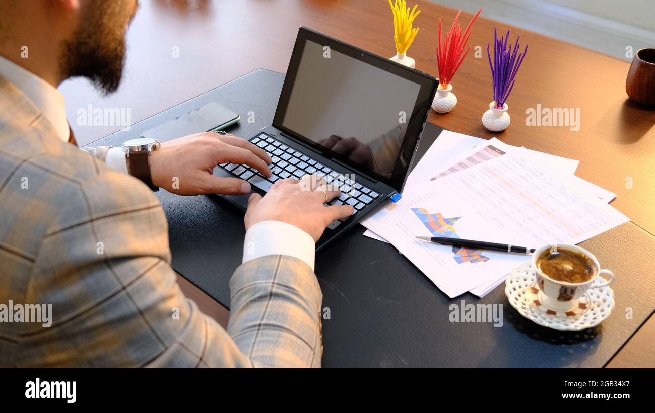 hombre de negocios bebiendo café y trabajando con computadora en el escritorio de la oficina. Foto de stock