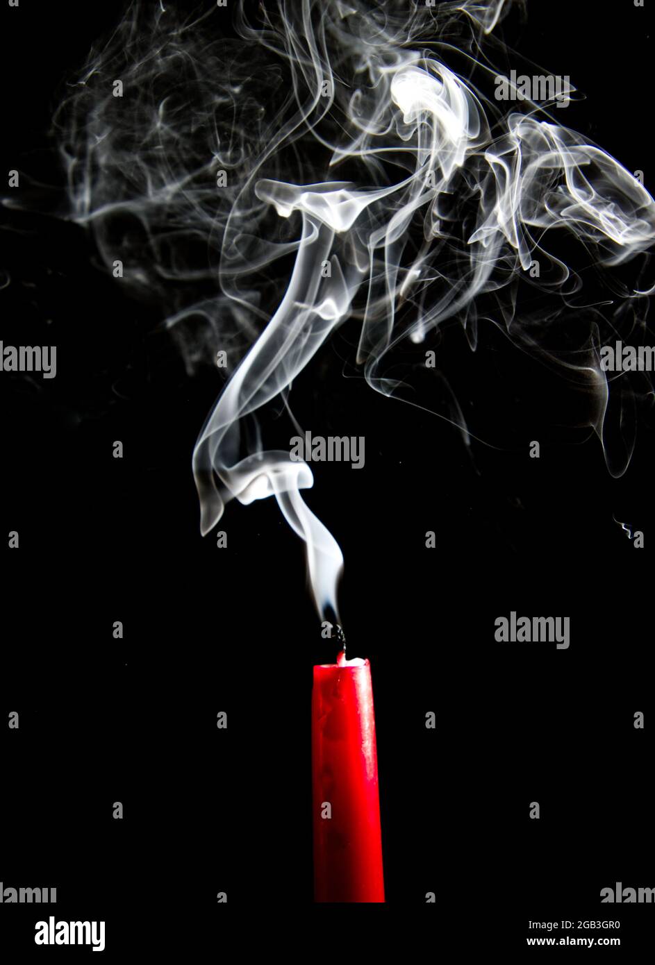 El humo que sale de una vela roja extinguida contra un fondo negro  Fotografía de stock - Alamy