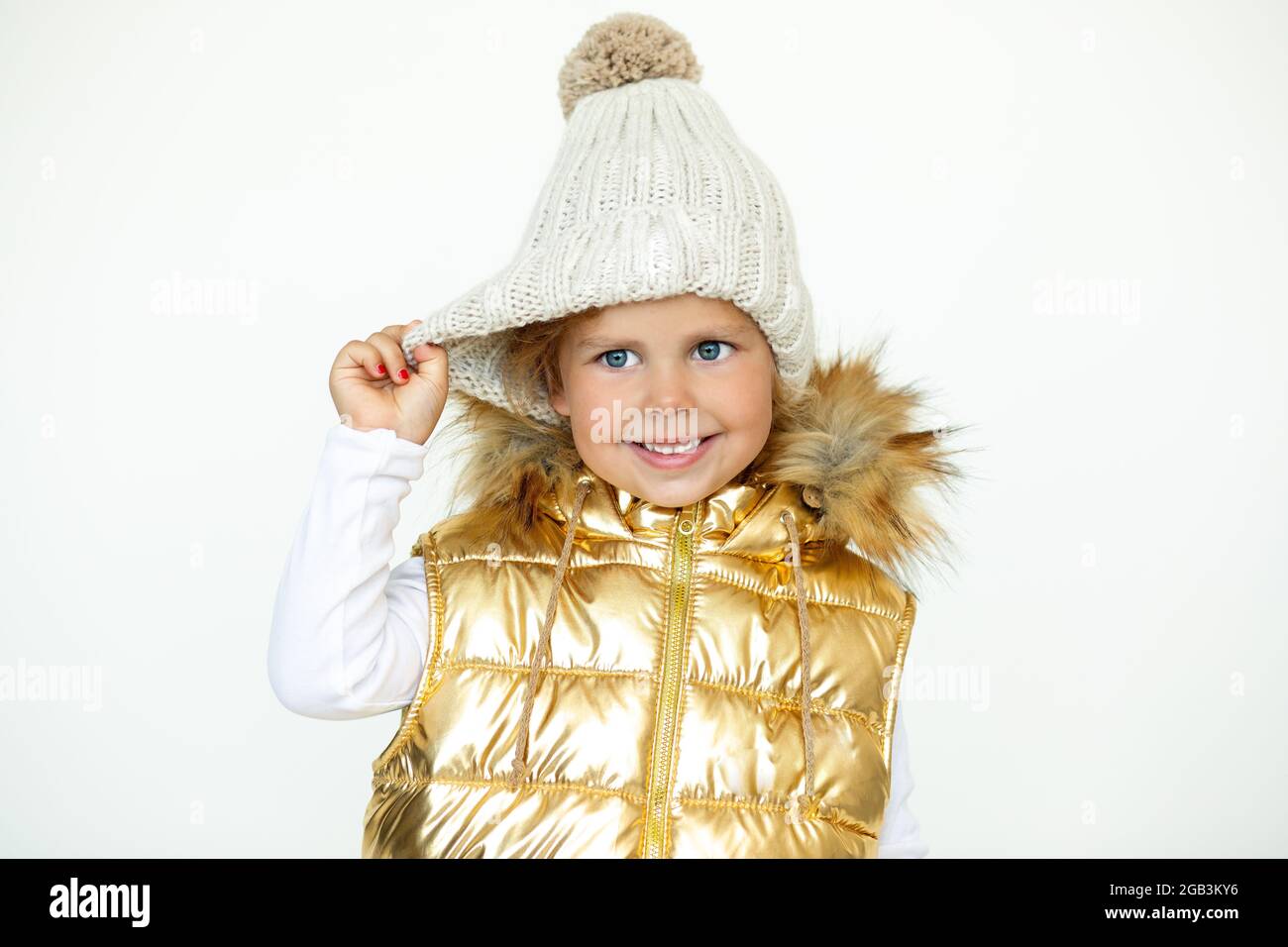 Moda infantil. Foto de niña en cálido sombrero de lana natural y chaleco dorado abrigo niños con capucha, foto Fotografía de stock Alamy