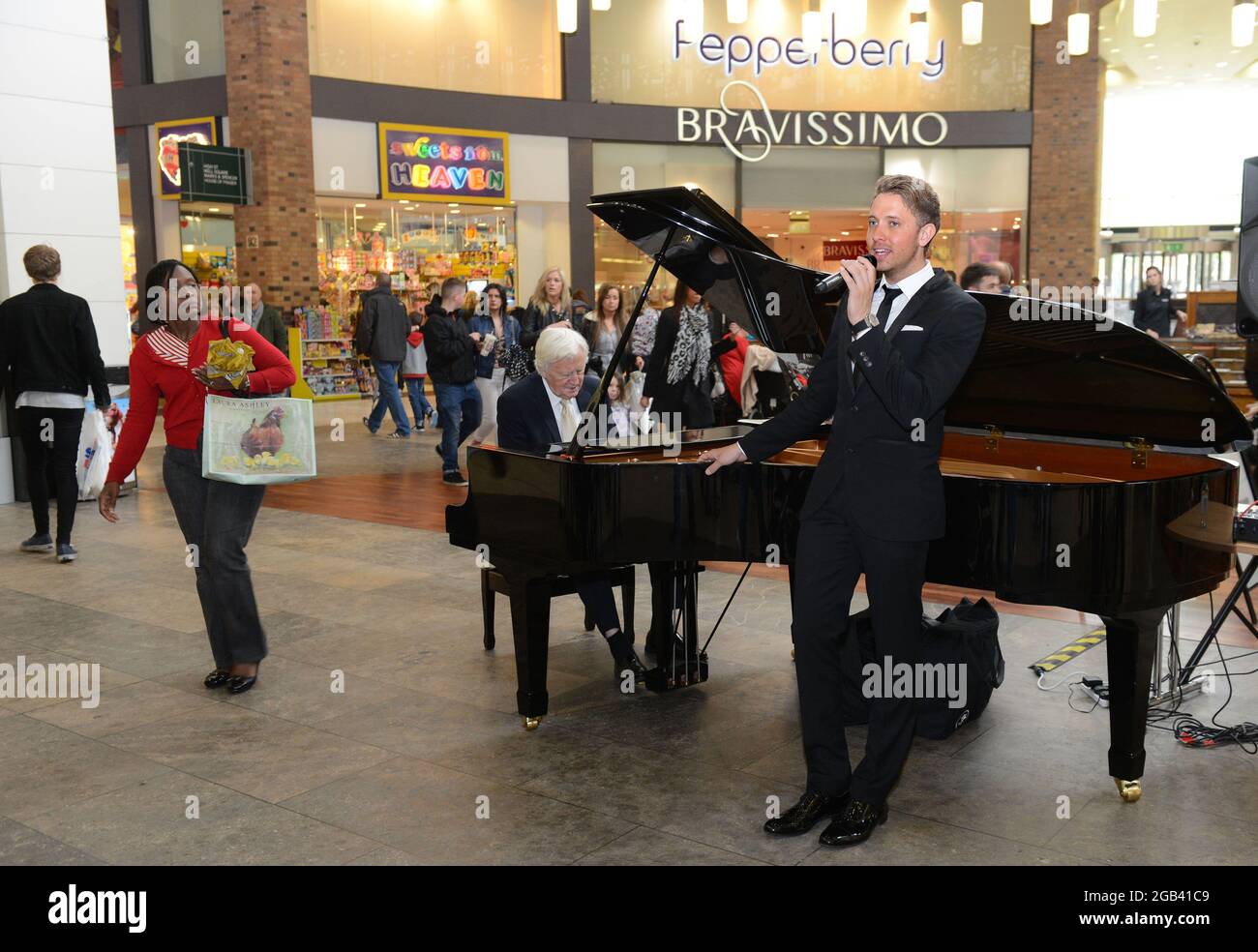 El vocalista Jordan Williams y el pianista de jazz Brian Dee entretiene a los compradores en Touchwood Shopping Center, Solihull, Gran Bretaña, Reino Unido Foto de stock