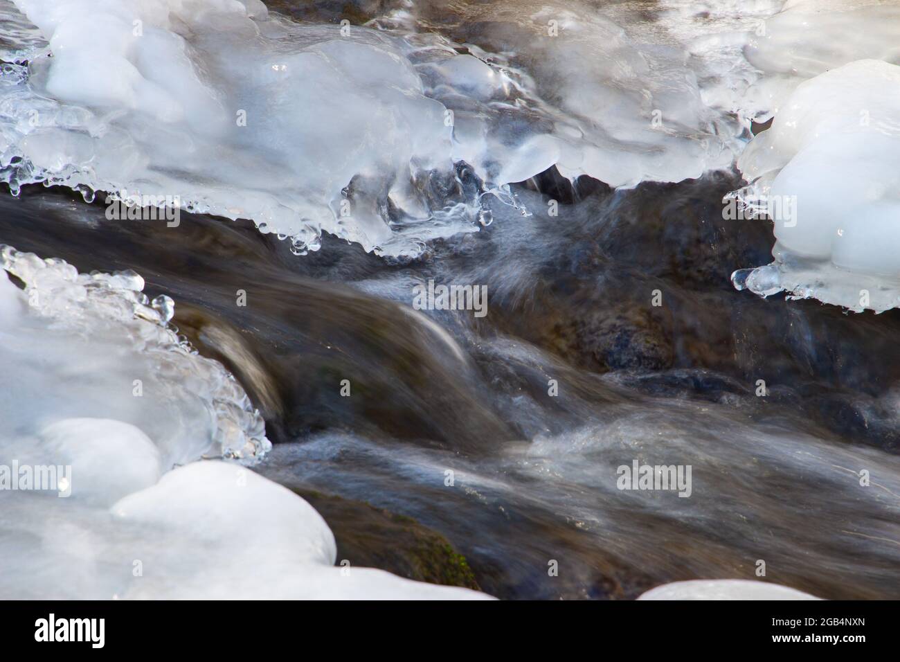 Agua fluyendo bajo hielo derretido, concepto de calentamiento global Foto de stock