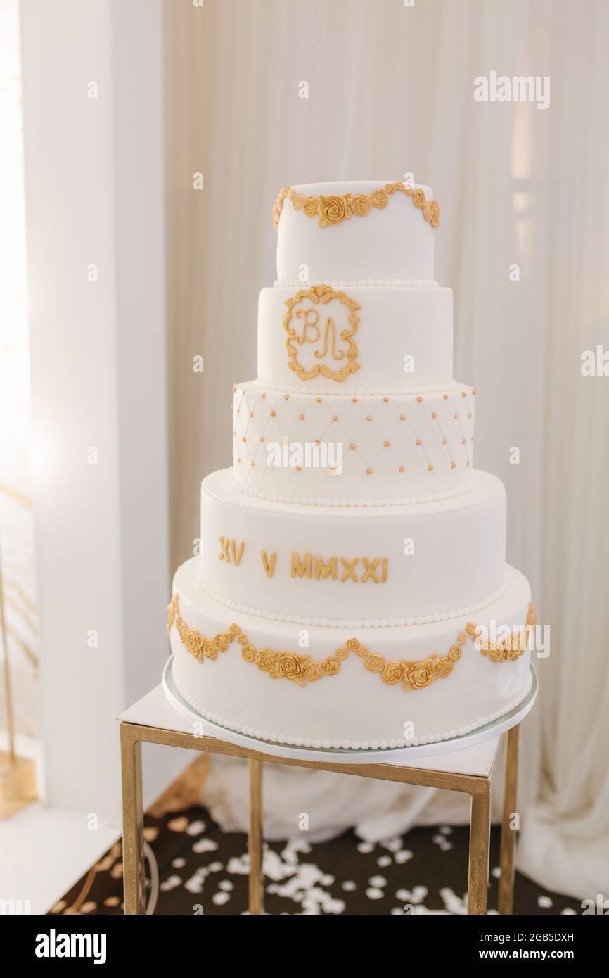 Pastel de boda blanco de cinco pisos decorado en estilo dorado. Hermosas  dulces para novio y novia Fotografía de stock - Alamy