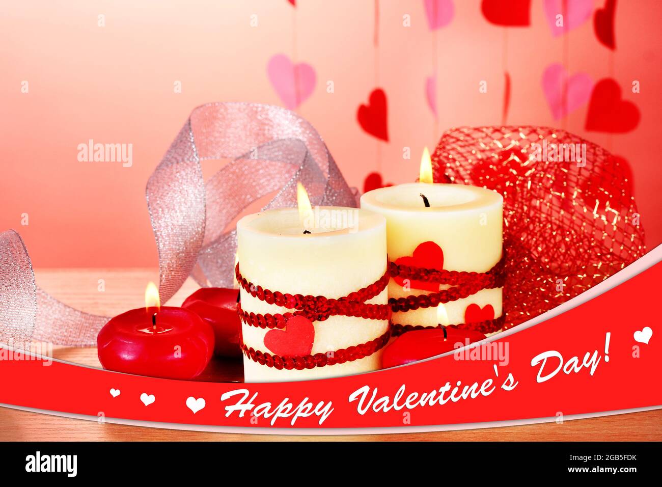 Velas para el Día de San Valentín en la mesa de madera sobre fondo rojo  Fotografía de stock - Alamy