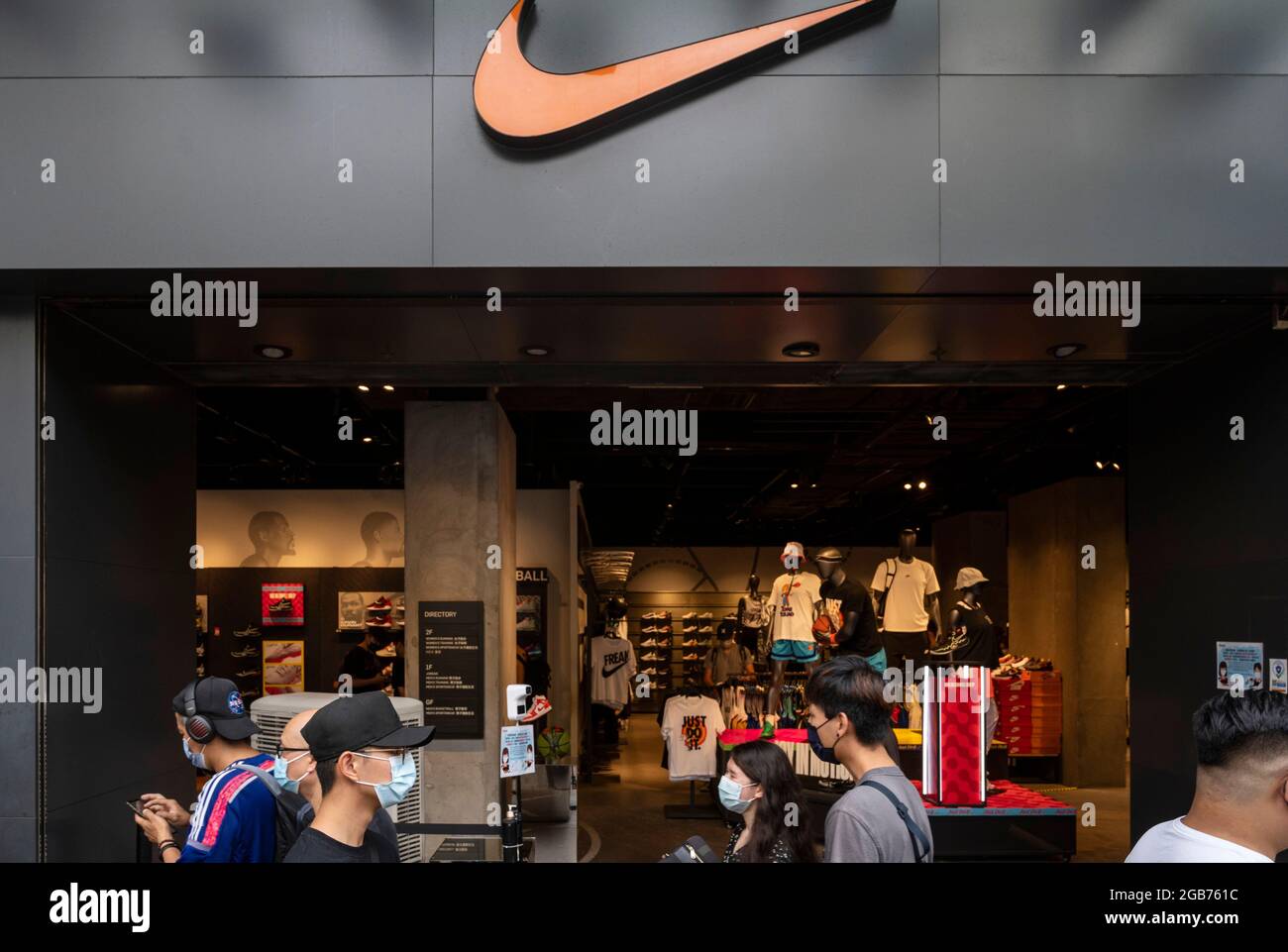 Los peatones pasan por delante de la marca de ropa deportiva multinacional  americana, la tienda Nike y su logotipo visto en Hong Kong Fotografía de  stock - Alamy