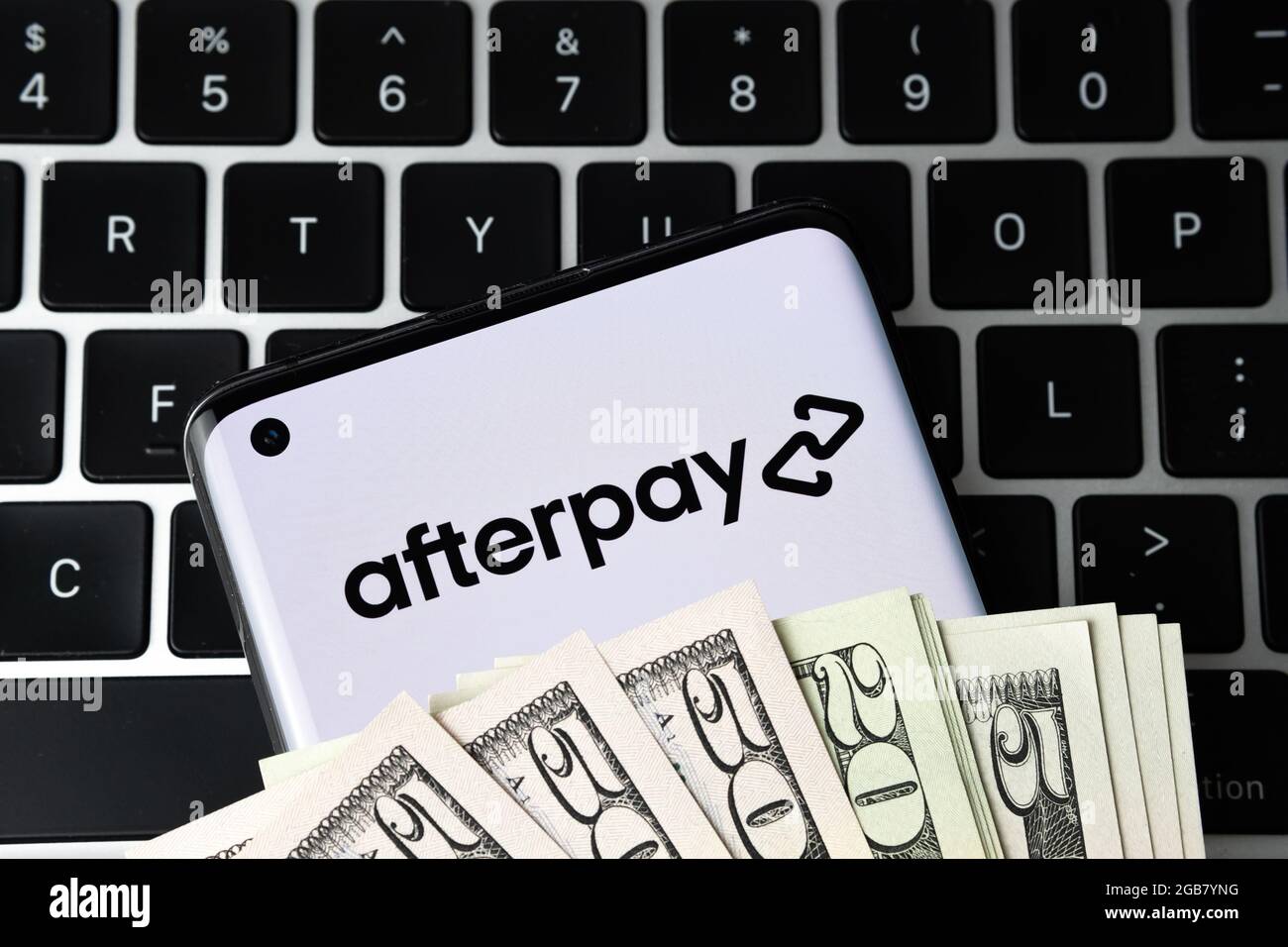 Logotipo de la empresa Afterpay visto en el smartphone cubierto de dólares y colocado en el teclado. Comprar ahora pagar más tarde empresa. Stafford, Reino Unido, 2 de agosto de 2 Foto de stock