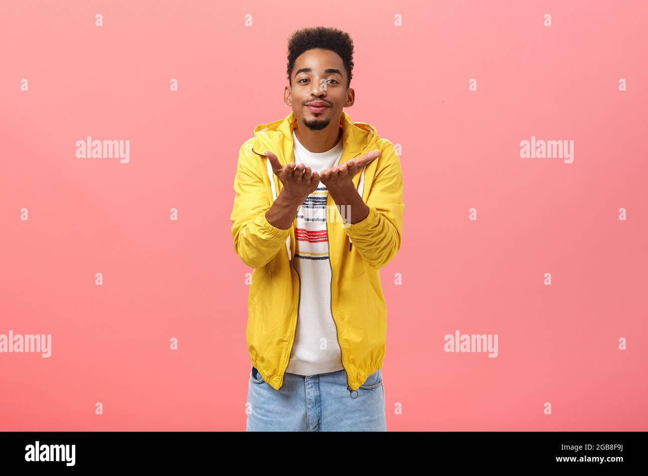 Sopla besos dulces. Hombre bonito y elegante con barba y peinado afro  doblándose hacia los labios plegables de la cámara y sonriendo enviando  mwah Fotografía de stock - Alamy