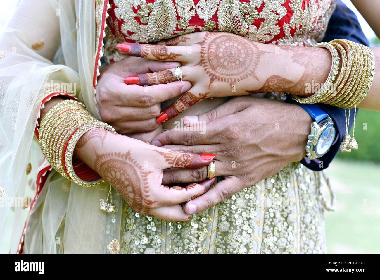 Una foto de cerca de una pareja joven abrazando y mostrando sus anillos de boda en la india Foto de stock