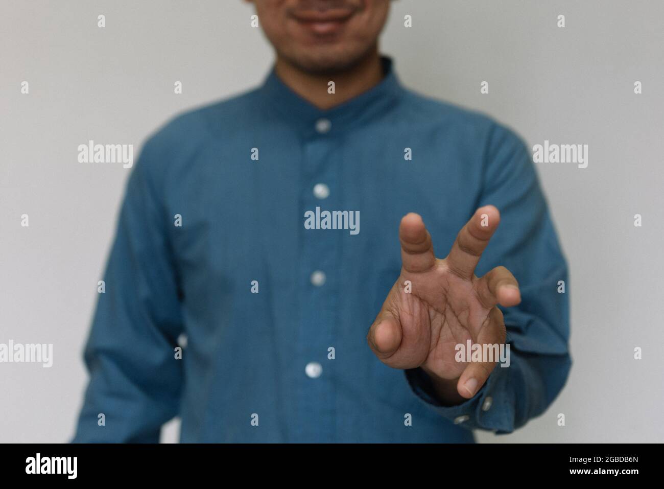 Hombre joven guapo con camisa azul claro con diferentes comportamientos en el trabajo Foto de stock