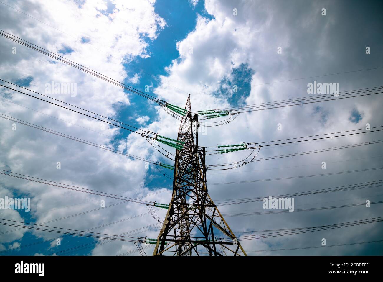 Torres de transmisión de electricidad o pilones con cables y cielo nublado sobre el fondo. Transmisión de corriente de alta tensión. Industrial o eléctrico tr Foto de stock