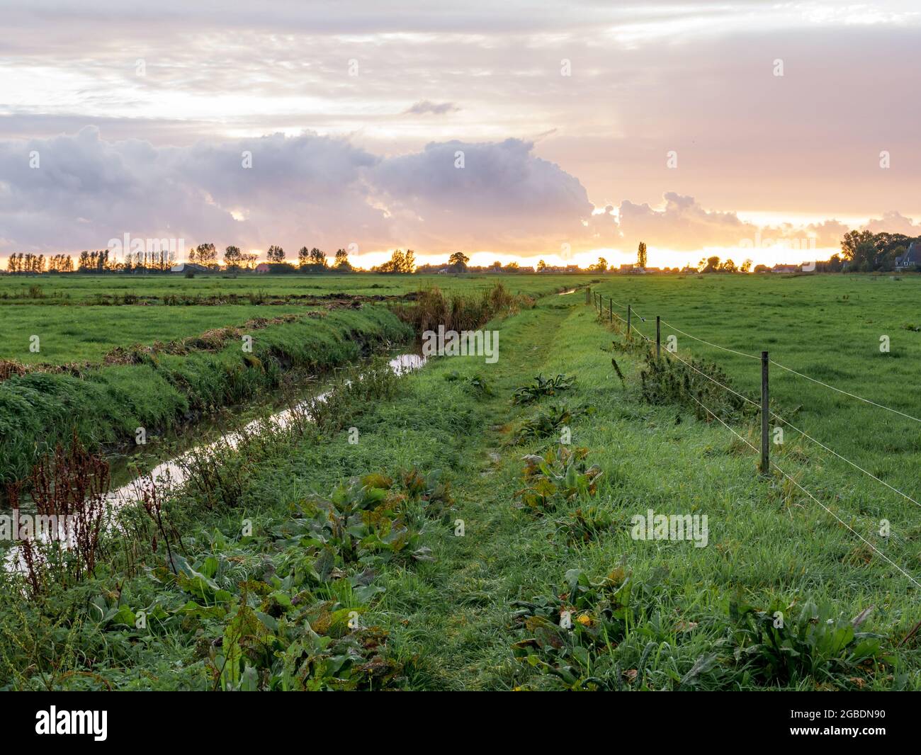 Panorama de las tierras de labranza y la zanja al atardecer en Ruterpolder cerca de la ciudad de IJlst, Frisia, Holanda Foto de stock