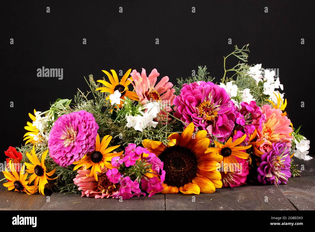 Hermoso ramo de flores brillantes sobre mesa de madera sobre fondo negro  Fotografía de stock - Alamy