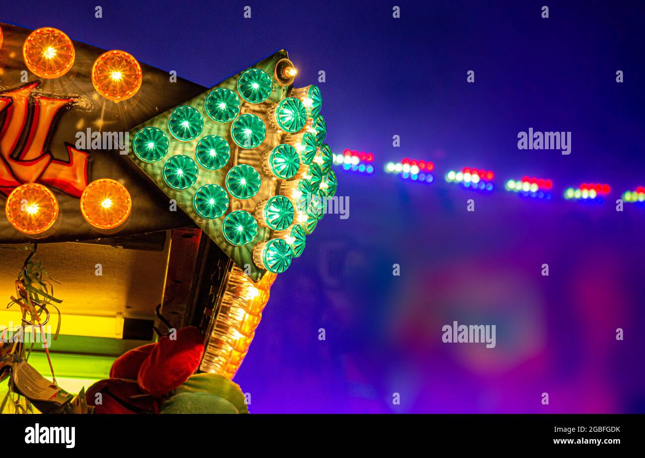 verde: luces de carnaval de color rojo. bombillas en el campo de la feria de paseo con fondo borroso Foto de stock