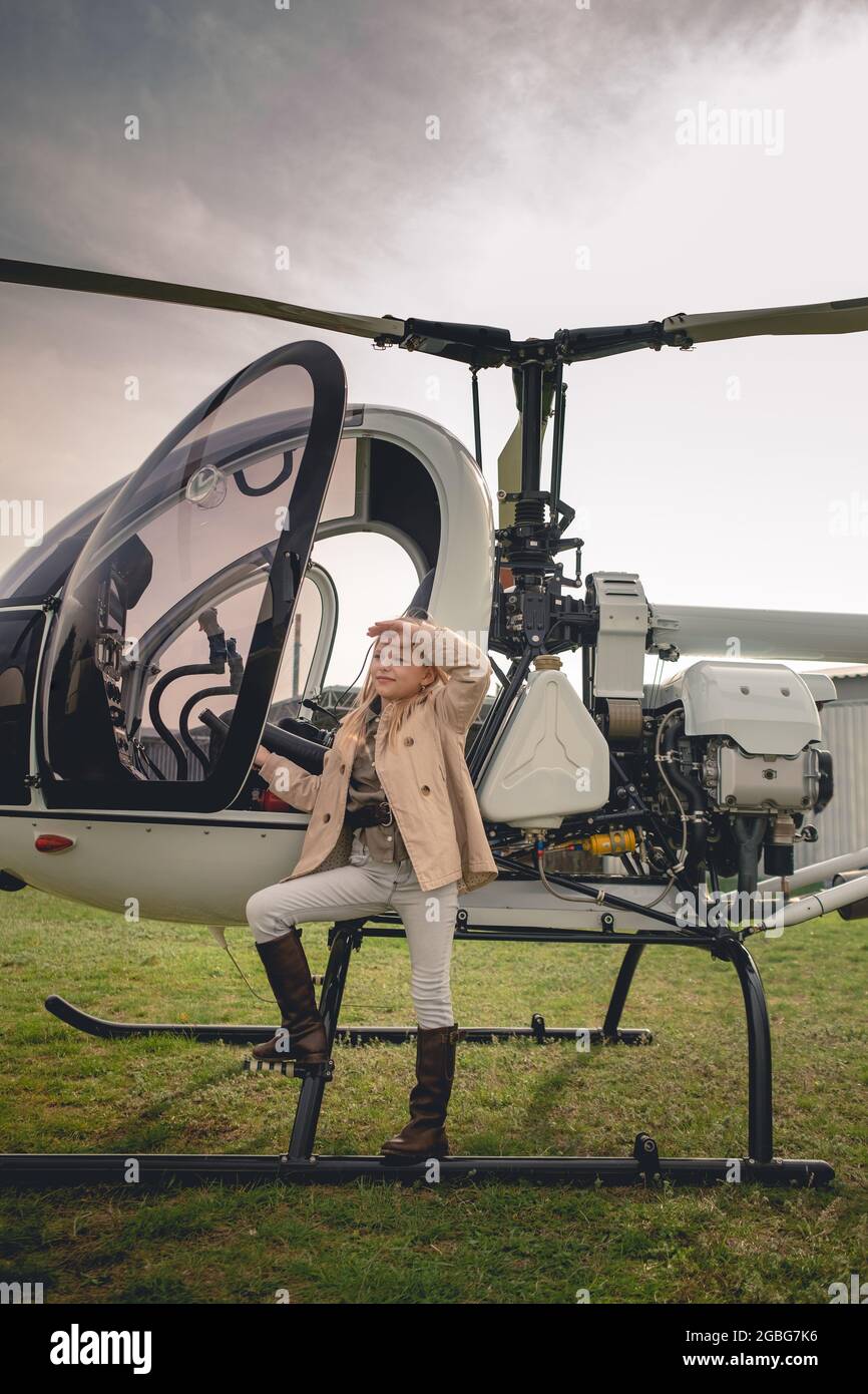Rubia Tween chica cerca de helicóptero mirando a la distancia Foto de stock