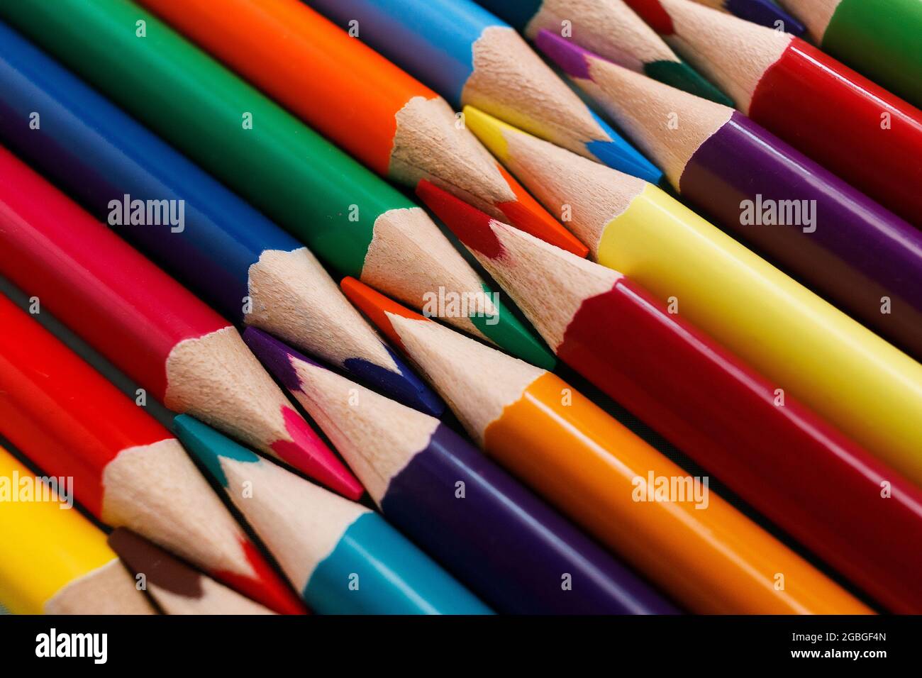 Los lápices de colores afilados se encuentran en un primer plano de fila.  Sólido fondo abstracto de lápices de varios colores de madera. Estos son  materiales escolares Fotografía de stock - Alamy