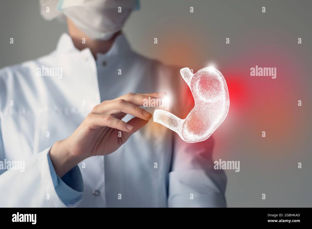 La doctora toca el estómago virtual en la mano. Foto borrosa, órgano humano de mano, resaltado en rojo como símbolo de la enfermedad. Servicio hospitalario sanitario Foto de stock