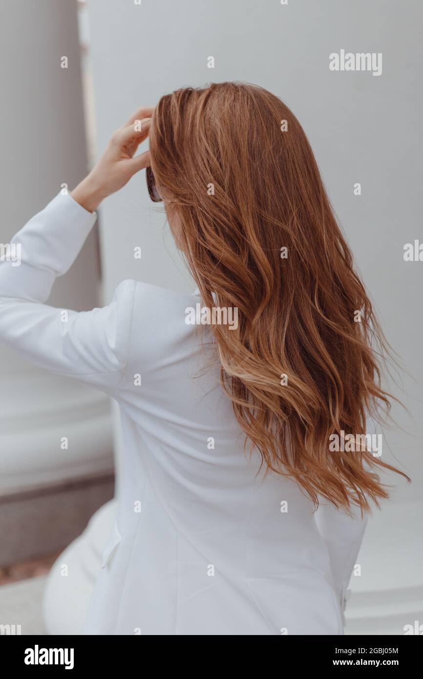 Chica de belleza con pelo rizado marrón. Cabello ondulado marrón sano y  largo. Hermosa mujer joven. Vista trasera Fotografía de stock - Alamy