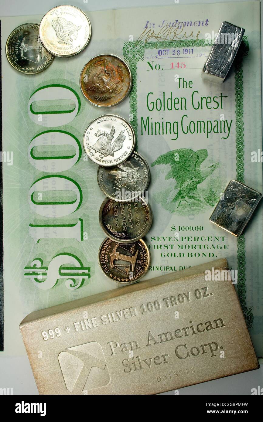 Silver Bullion and Antique $1.000 Mining Company Bond Foto de stock