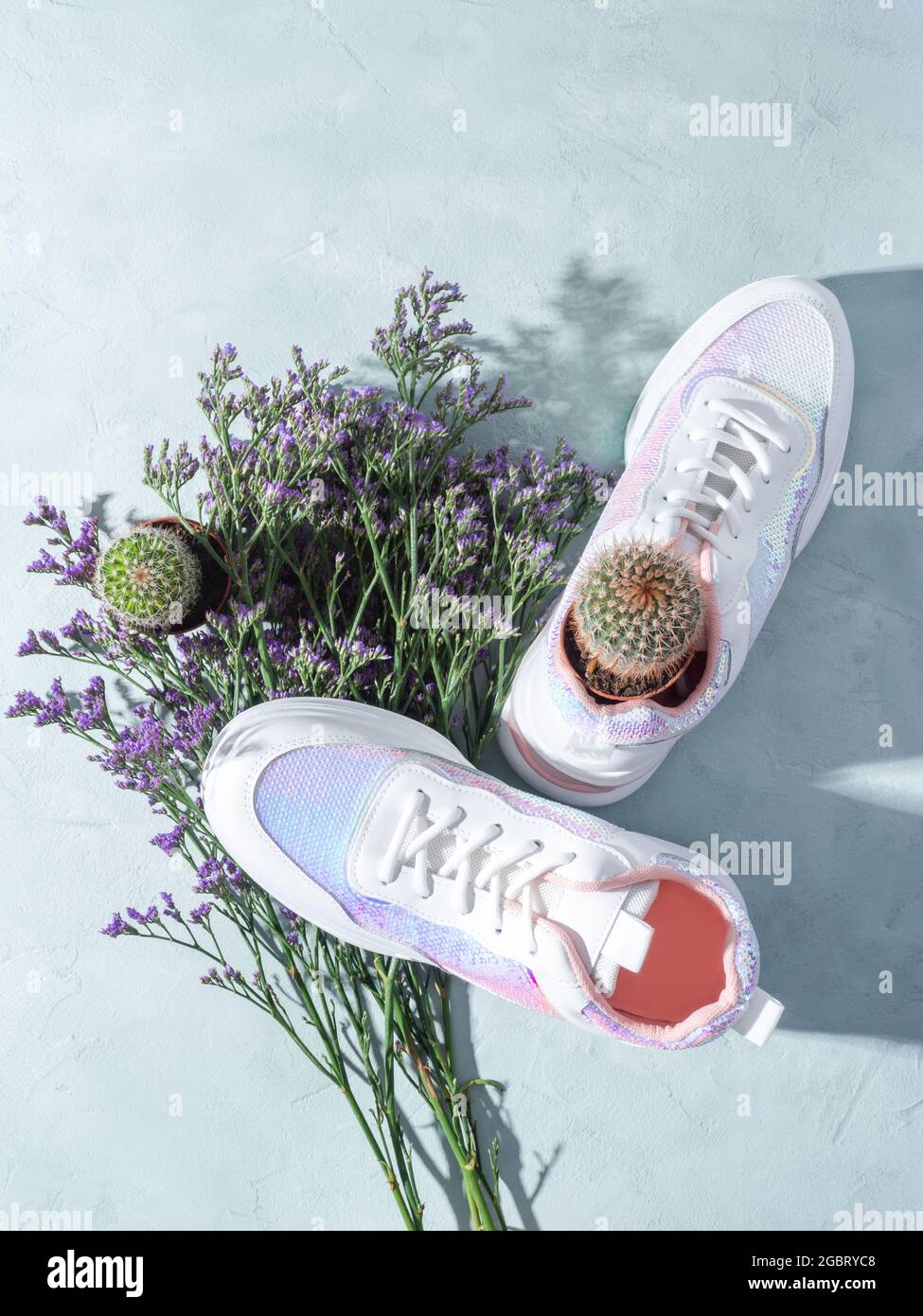 Zapatillas de lona blancas con lentejuelas y flores moradas sobre fondo  turquesa Fotografía de stock - Alamy