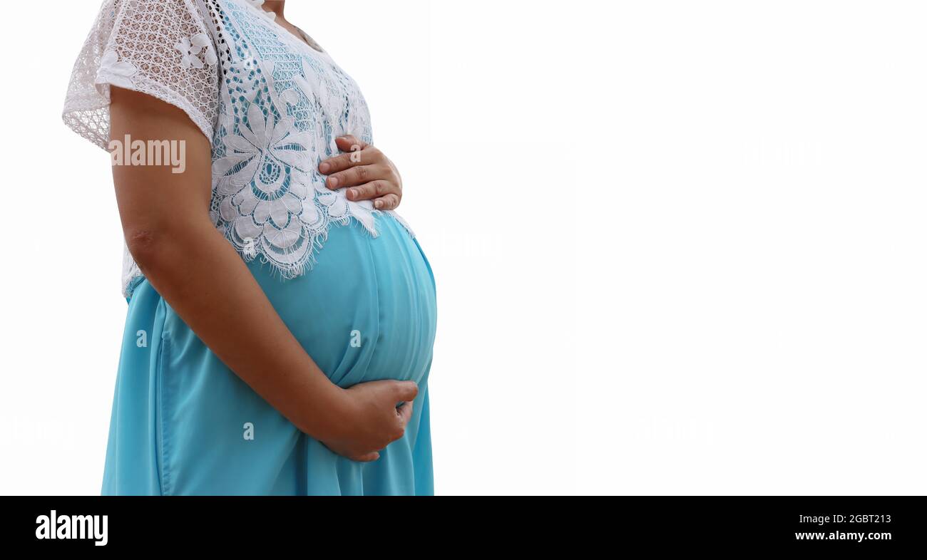 Mujer embarazada en un vestido azul aislado sobre fondo blanco y tiene senderos de recorte. Foto de stock