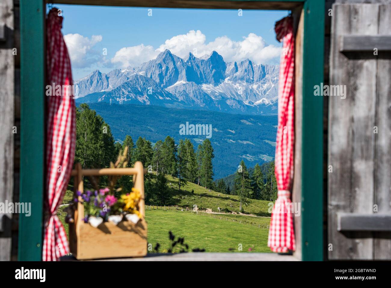 Vista desde la ventana de madera de Hoher Dachstein y el macizo de Dachstein. Picos montañosos cubiertos de nubes. Alta Austria-Estiria, Austria Foto de stock
