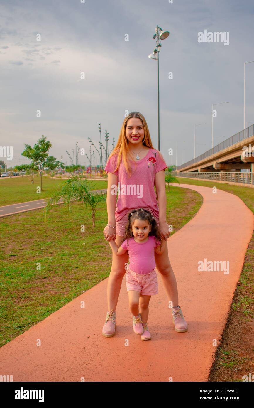 Mamá e hija vestidas igual en un parque al aire libre jugando unos con  otros Fotografía de stock - Alamy