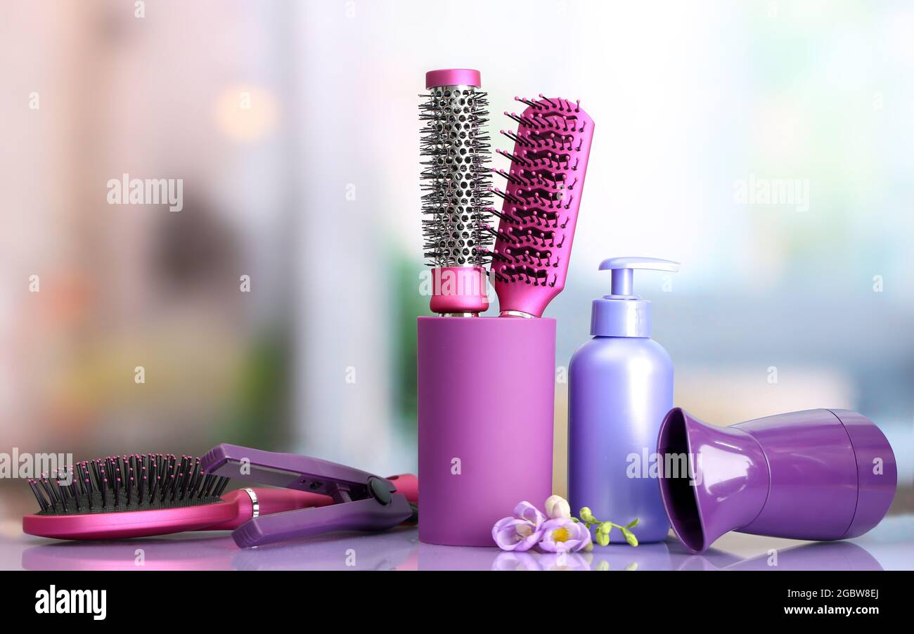 Cepillos para el cabello, secador de pelo, planchas y botella de cosméticos  en salón de belleza Fotografía de stock - Alamy