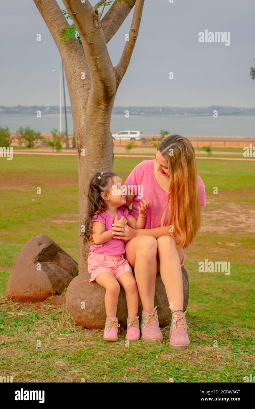 Mamá e hija vestidas igual en un parque al aire libre jugando unos con otros Fotografía de stock - Alamy Mamá e hija vestidas igual en un parque al aire libre jugando unos con otros Fotografía de stock - Alamy