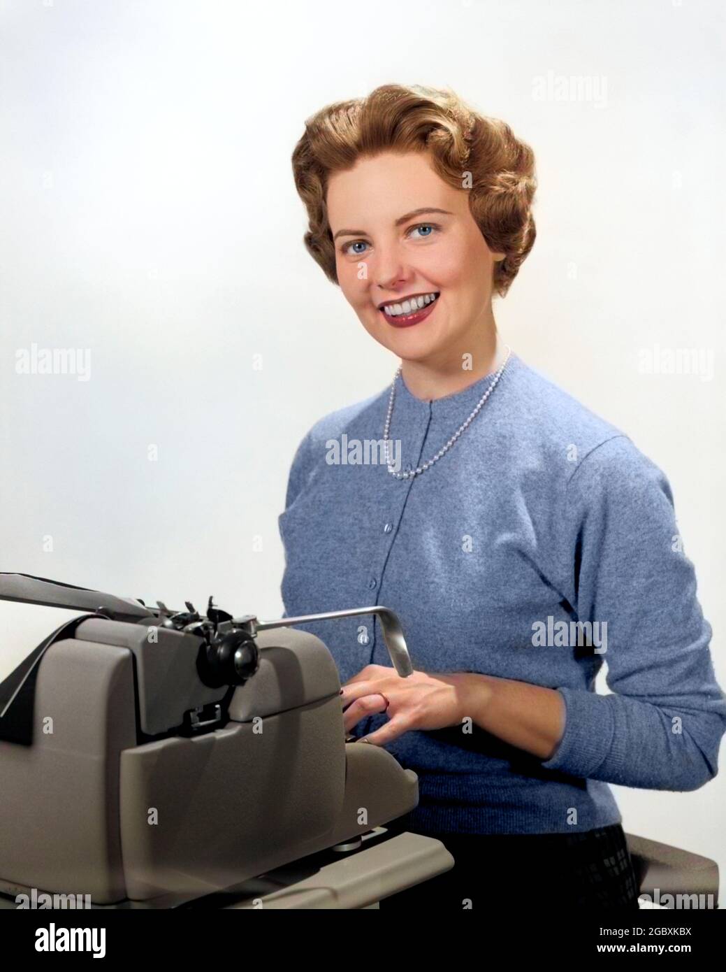 1950S SONRIENTE SECRETARIO DE RETRATO SENTADO DETRÁS DE MÁQUINA DE ESCRIBIR - O1276C HAR001 PERLAS DE HARS JOVEN AMIGO DE COMUNICACIÓN ADULTA JOVEN ASISTENTE MUJERES TRABAJOS ESTUDIO FOTOGRAFIADO RETRATOS HEALTHINESS SENTADO COPIA ESPACIO DE MEDIA LONGITUD SEÑORAS PERSONAS CONTACTO OJO FELICIDAD MECANOGRAFÍA ATENCIÓN AL CLIENTE OFICIO TRABAJADORES OCUPACIONES SMILES GAL FRIDAY MANUAL MÁQUINA DE ESCRIBIR ADMINISTRADOR SECRETARIOS ESTILOSOS MECANÓGRAFOS STRAND AMANUENSIS CARDIGAN JUVENIL JOVEN ADULTA JOVEN MUJER CAUCÁSICA CLÉRIGO ÉTNICO HAR001 MECANÓGRAFO ANTIGUO Foto de stock