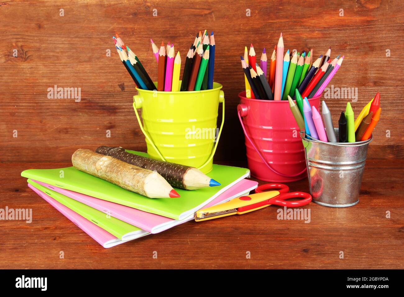 Lápices de colores con útiles escolares sobre fondo de madera Fotografía de  stock - Alamy