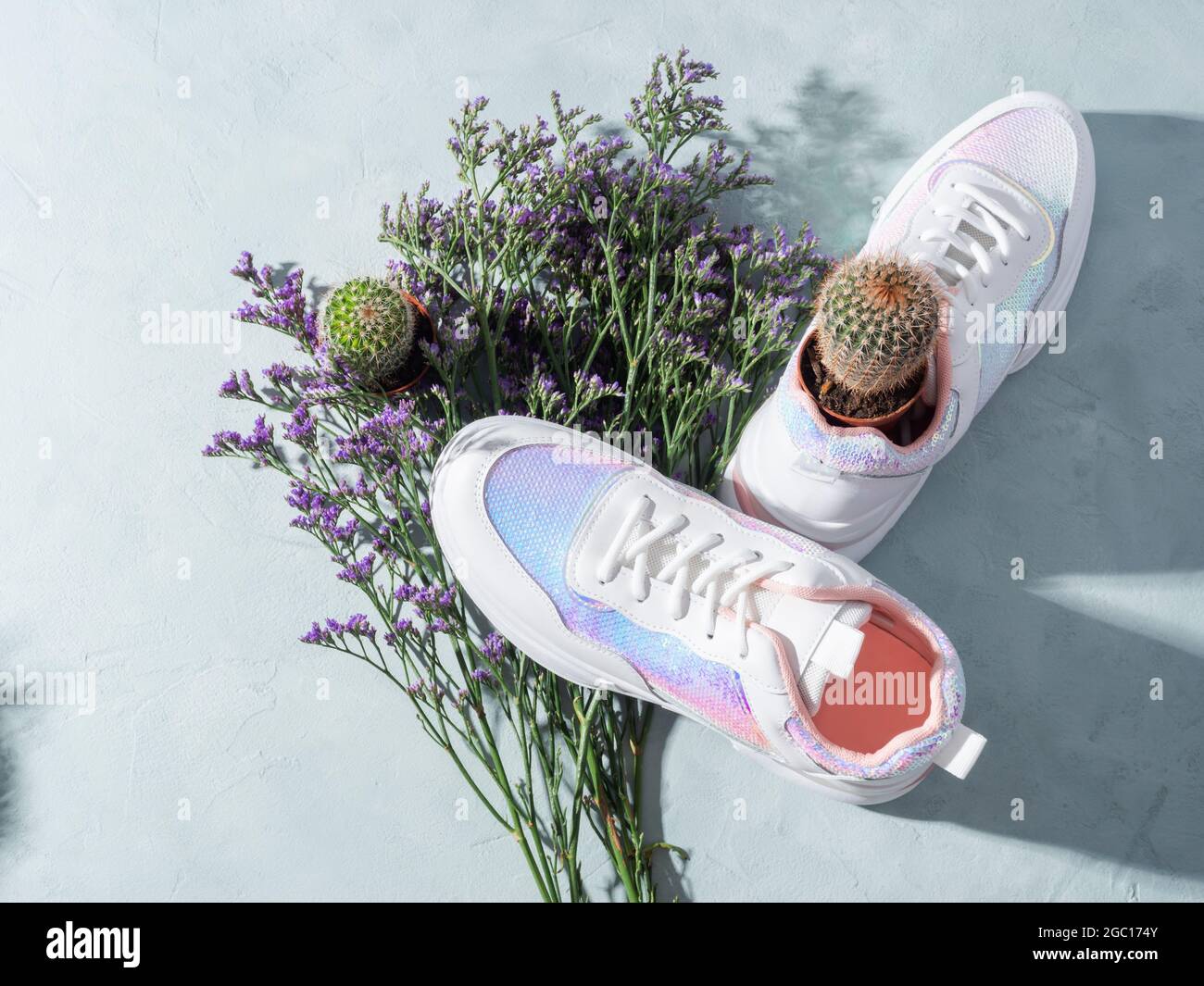 Zapatillas de lona blancas con lentejuelas y flores moradas sobre fondo  turquesa Fotografía de stock - Alamy