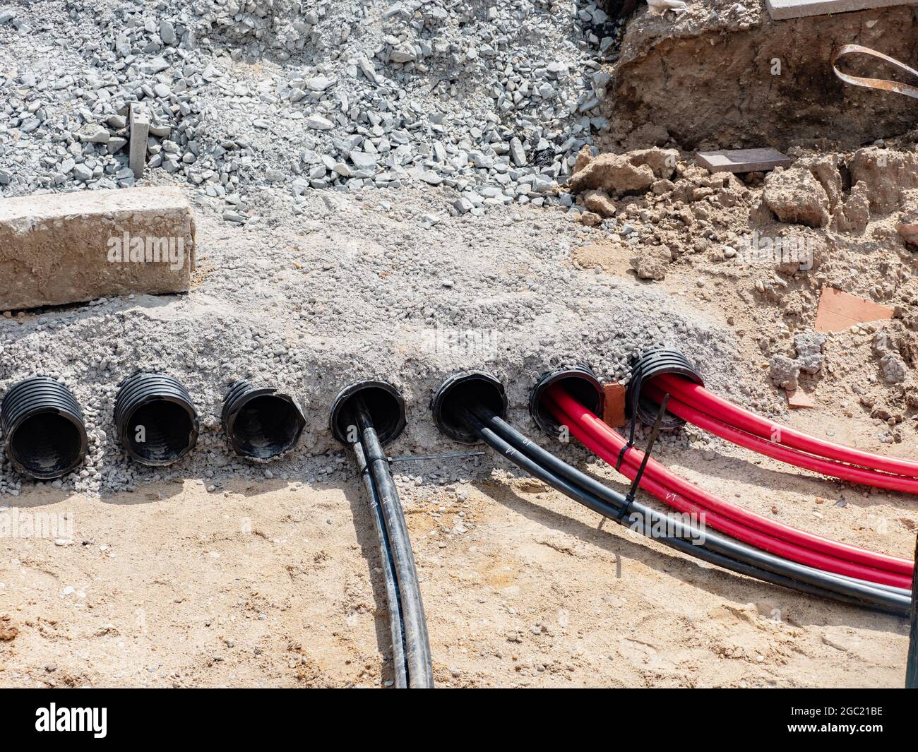 Cables de alta tensión en el suelo. Colocación del cable eléctrico en un tubo estriado de plástico de seguridad subterráneo, con servicio de asistencia de stock - Alamy